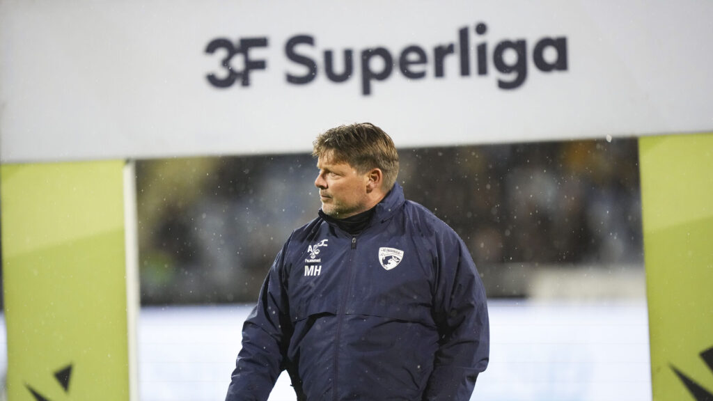 Michael Hansen foran et Superliga-skilt