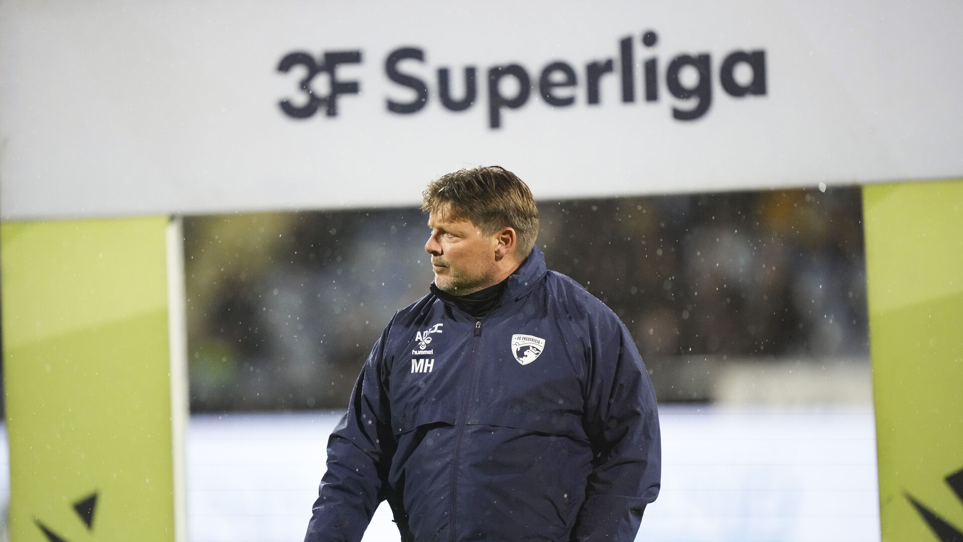 Michael Hansen foran et Superliga-skilt