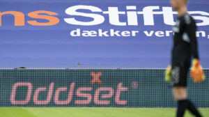 Oliver Christensen med en spilreklame i baggrunden