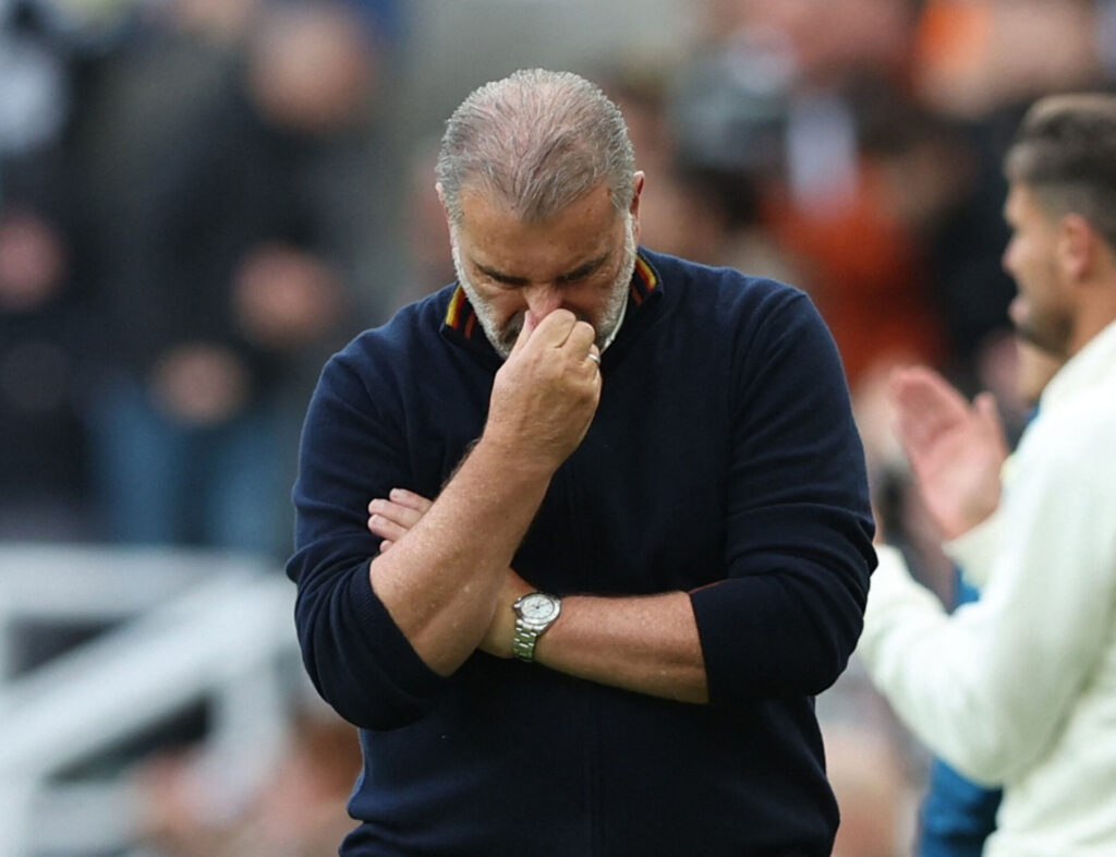 Ange Postecoglou har hovedet nedad og hånden på næsen.