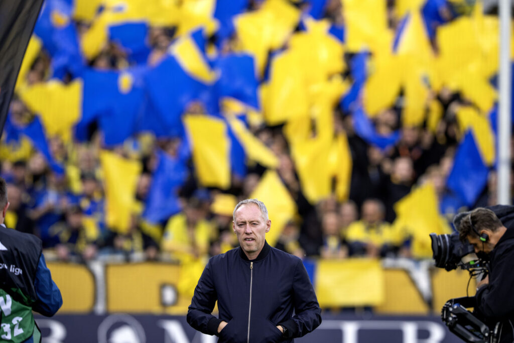 Steve Cooper går foran fans med hænderne i lommen.