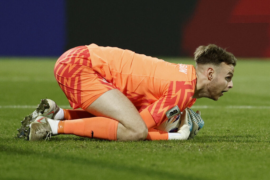 Elias Olafsson ligger på græsset med bolden i favnen.