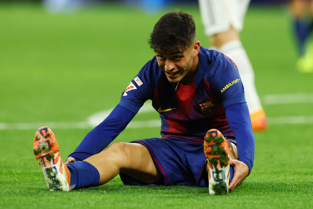 Pedri sidder i græsset under en kamp for FC Barcelona