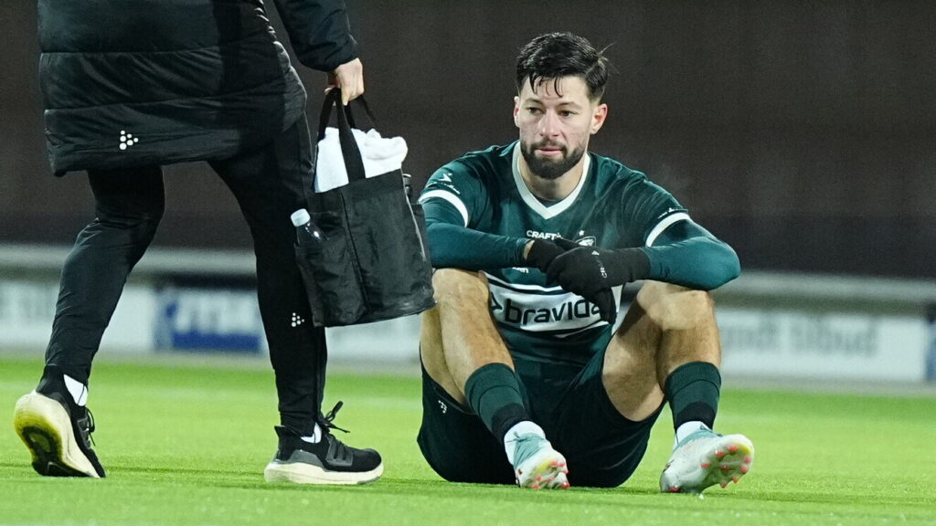 Kevin Yakob sidder på kunstgræsset