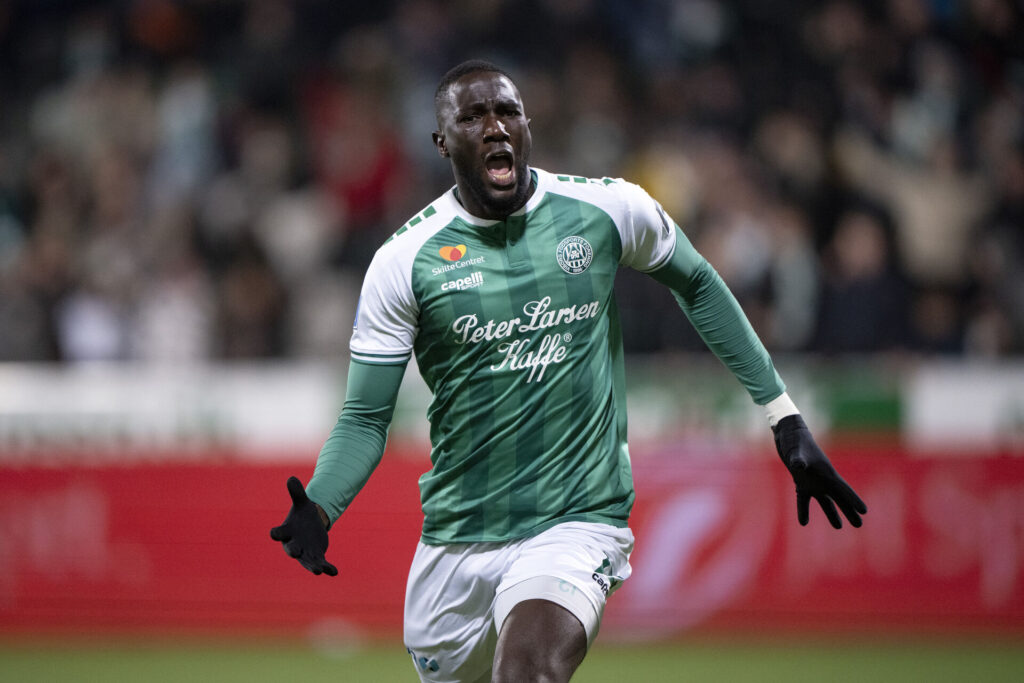 Alassana Jatta råber med armene ude til siden.