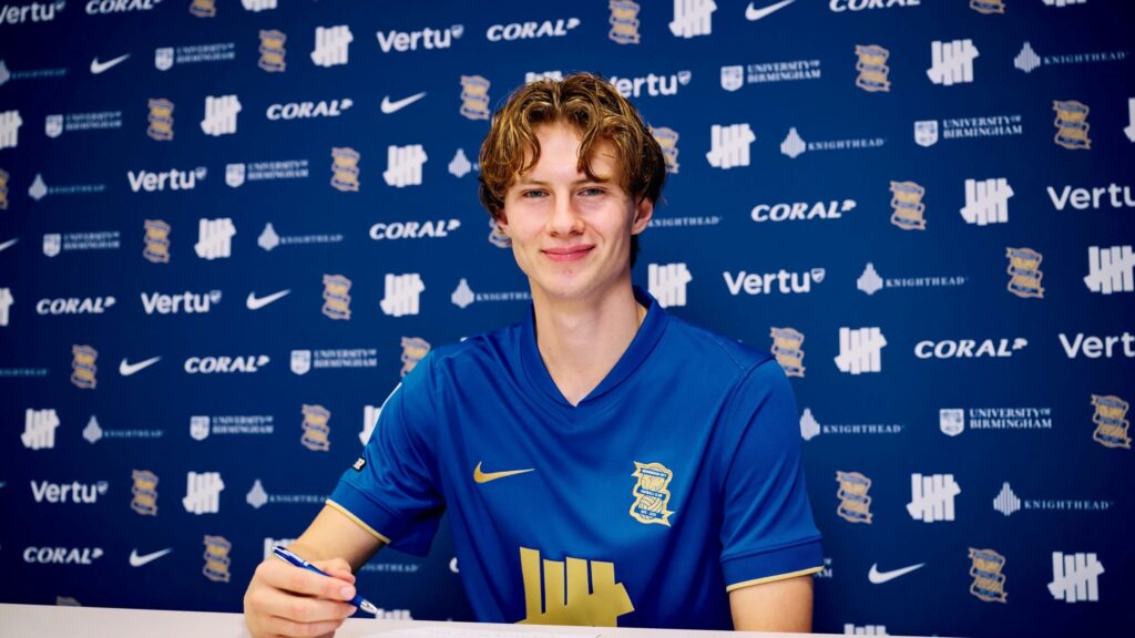 August Priske sidder iklædt en Birmingham-trøje med en kuglepen i hånden.