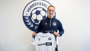 Emil Grønn Pedersen står med en hvid Vendsyssel FF-trikot i hænderne.