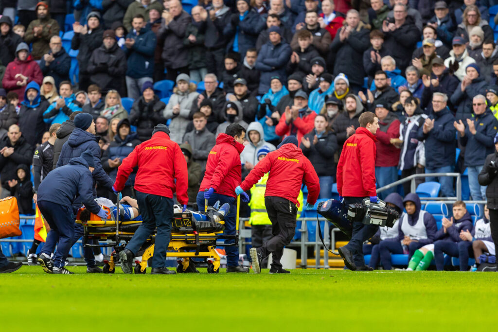 Yousef Salech bliver båret fra banen i lørdagens opgør mellem Cardiff og Stockport.