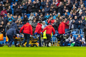Yousef Salech bliver båret fra banen i lørdagens opgør mellem Cardiff og Stockport.