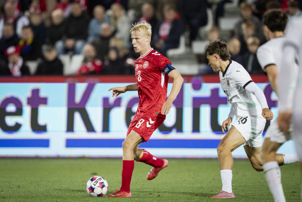 Oscar Højlund har bolden i kamp for Danmark.