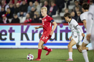 Oscar Højlund har bolden i kamp for Danmark.