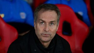 Kasper Hjulmand sidder på trænerbænken med en bekymret mine.