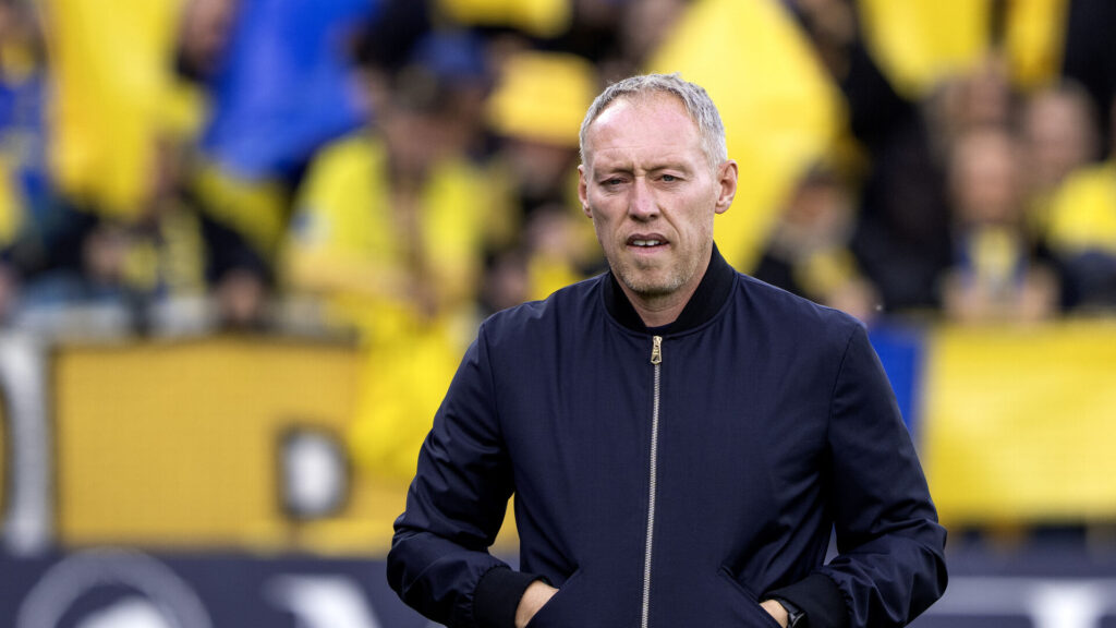 Steve Cooper med en masse blå og gule flag i baggrunden.