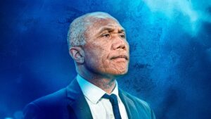 Antoine Kombouaré med blå baggrund.