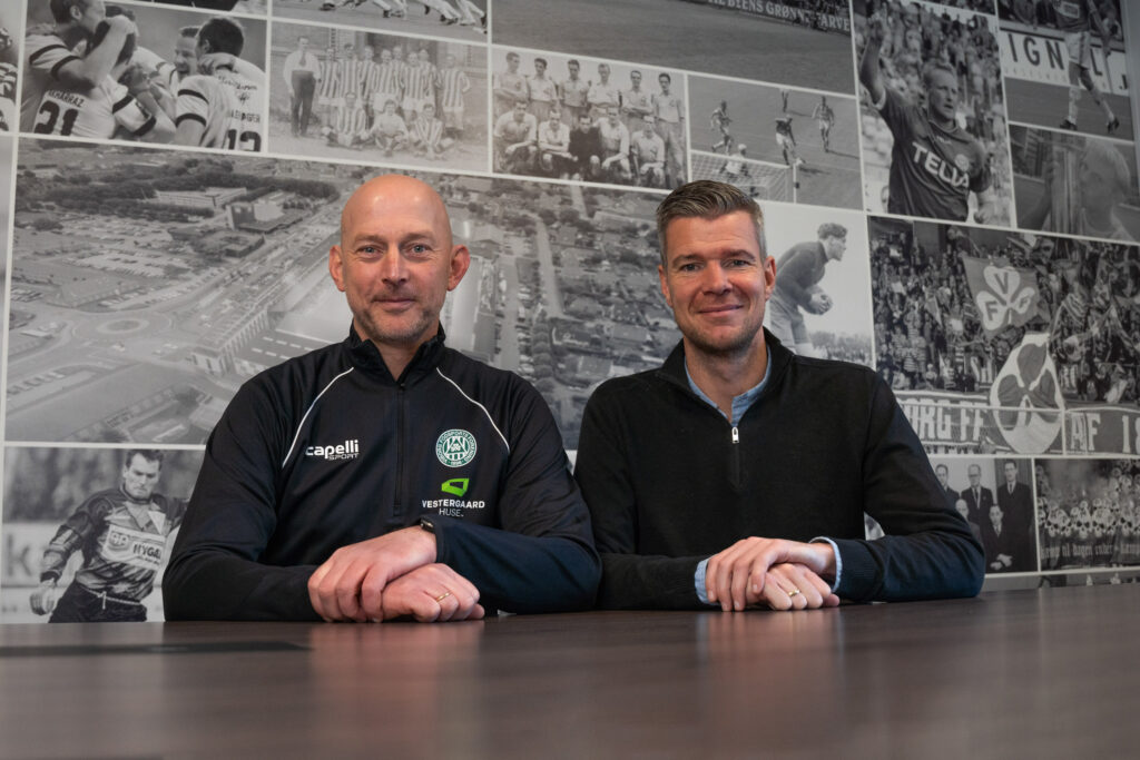 Ralf Pedersen og Mads Agesen sidder sammen ved et bord.