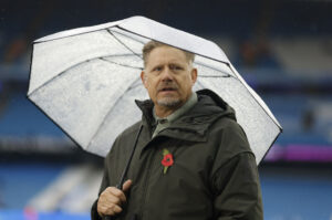 Peter Schmeichel under en paraply.