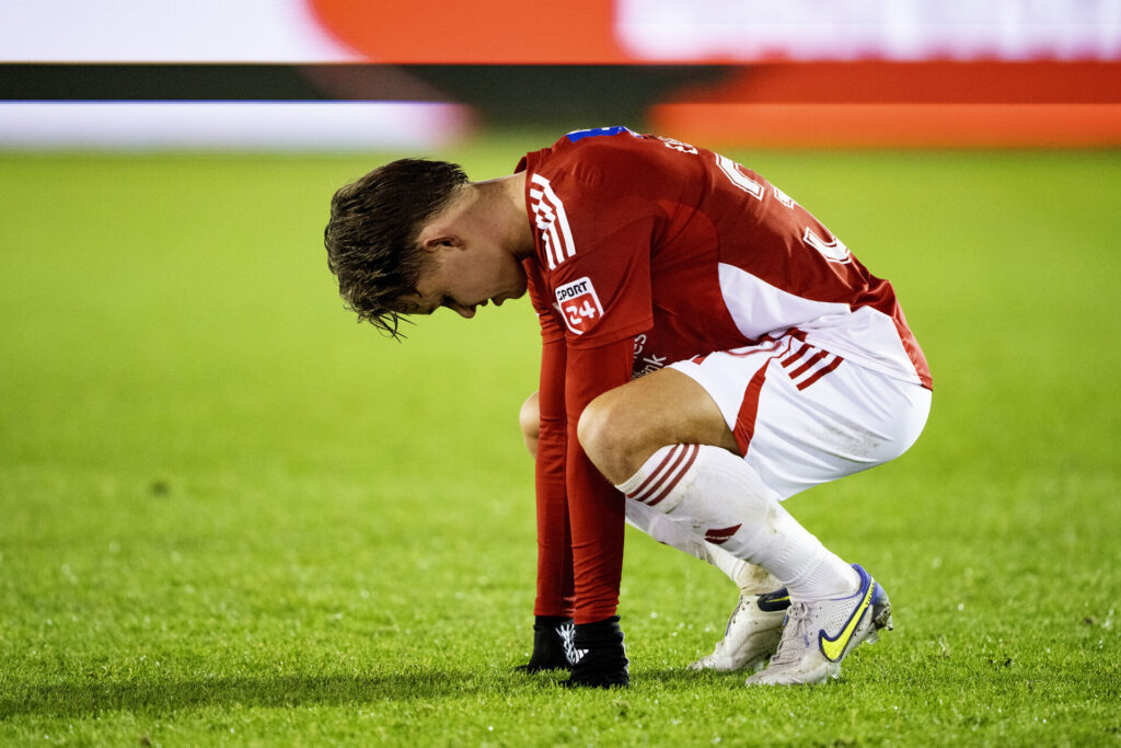 Mads Enggård sidder på hug med hovedet bøjet.