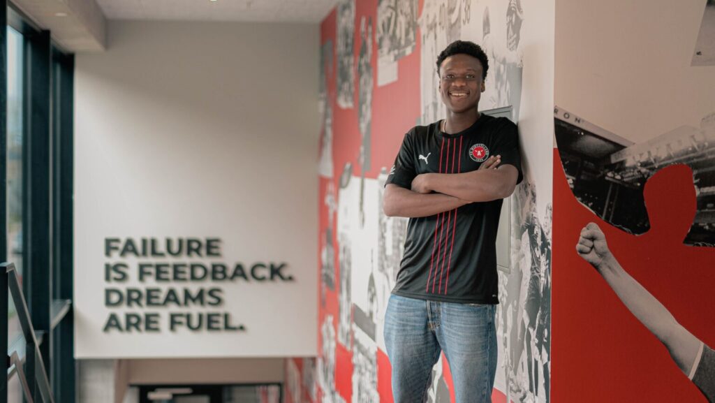 Emmanuel Alase poserer i en FCM-trøje.