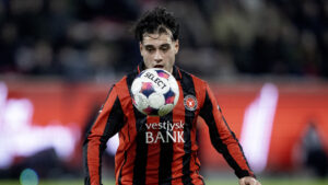 Aral Simsir med øjnene rettet mod bolden.