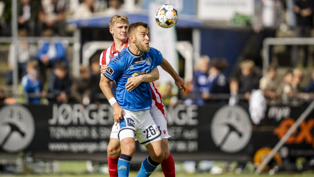 AaB's Bjarne Pudel i duel med Lyngbys Frederik Gytkjær.