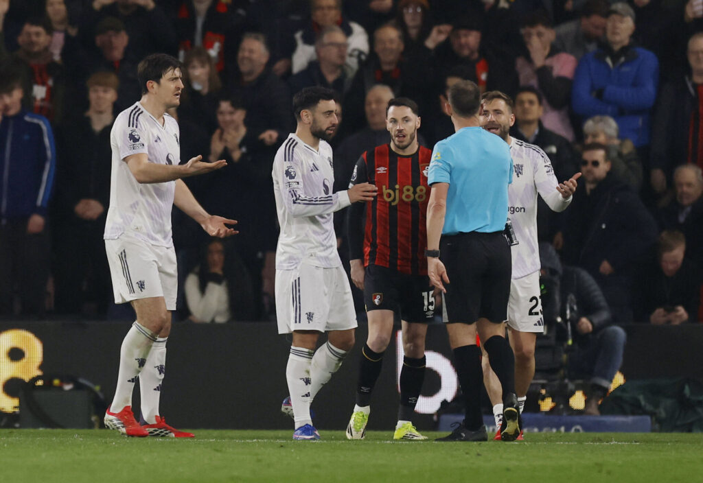 Harry Maguire, Bruno Fernandes, Adam Smith og Luke Shaw diskuterer med Stuart Attwell.