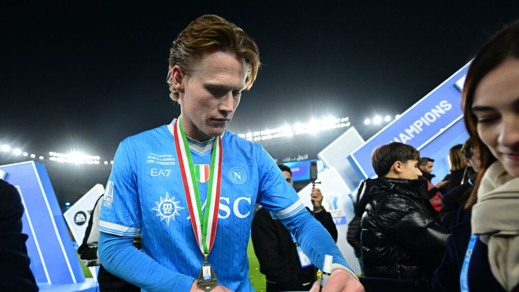 Scott McTominay skriver en autograf til en fan.