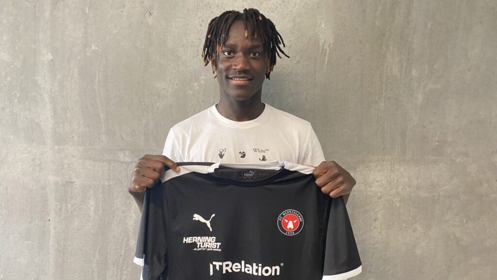 Alamara Djabi holder en FC MIdtjyllands-trikot op.