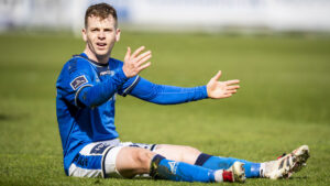 Sævar Atli Magnusson sidder med armene foran sig på græsset.