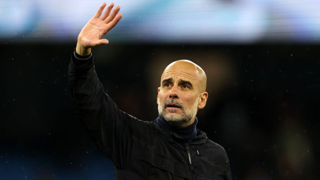Pep Guardiola står med højre arm oppe i luften.
