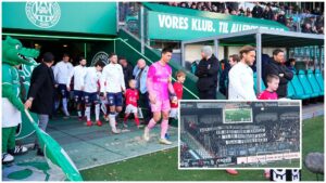 AGF-spillere på vej på banen. Banner på tribunen.