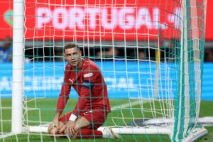 Cristiano Ronaldo på knæ inde i et fodboldmål.