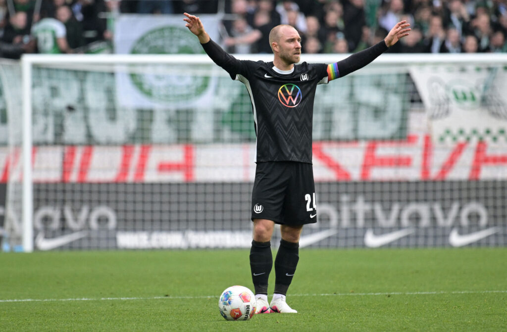 Christian Eriksen har armene i vejret inden et frispark