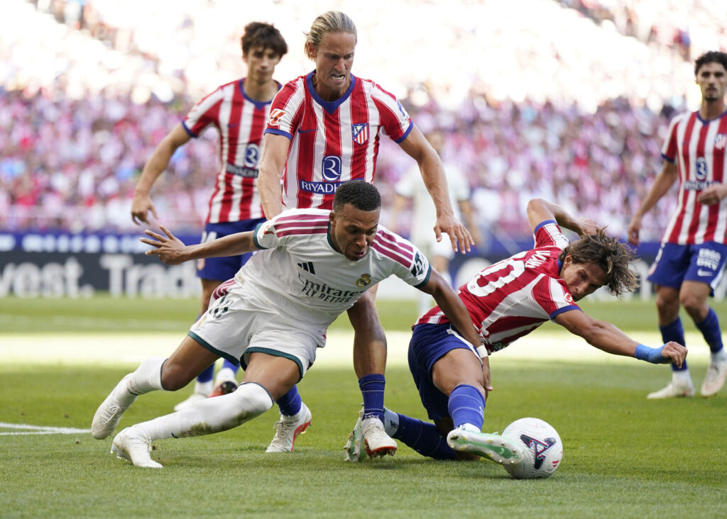 Kylian Mbappe i duel med Giuliano Simeone og Marcos Llorente i opgøret mellem Real Madrid og Atletico Madrid