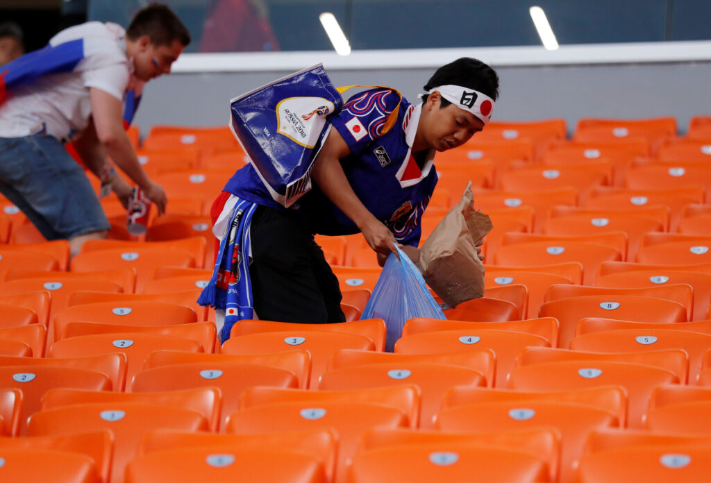 En japansk fodboldfan gør rent på et stadion i Rusland ved VM 2018.