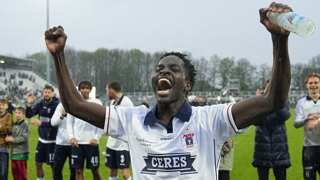 James Bogere står med armene over hovedet.