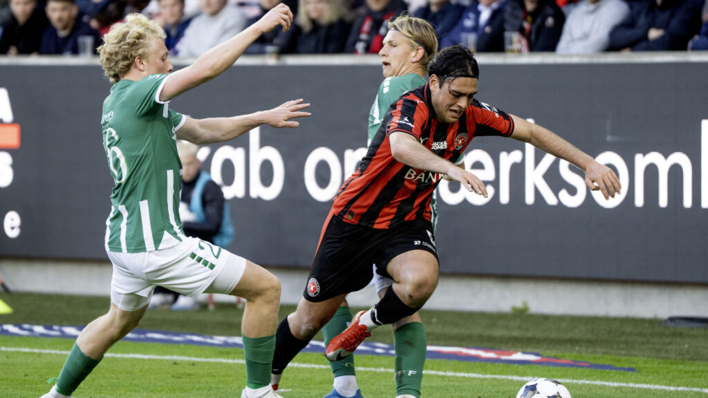 Aral Simsir løber forbi to Viborg-spillere.