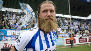 Bjørn Paulsen står med ryggen til fansene.