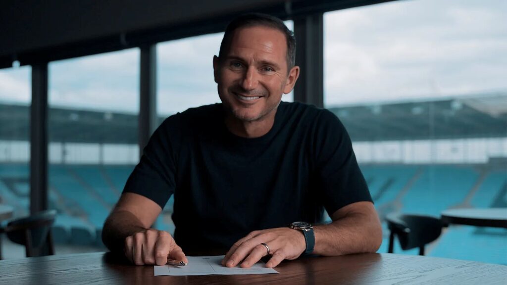 Frank Lampard med en et papir på et bord i Coventry.