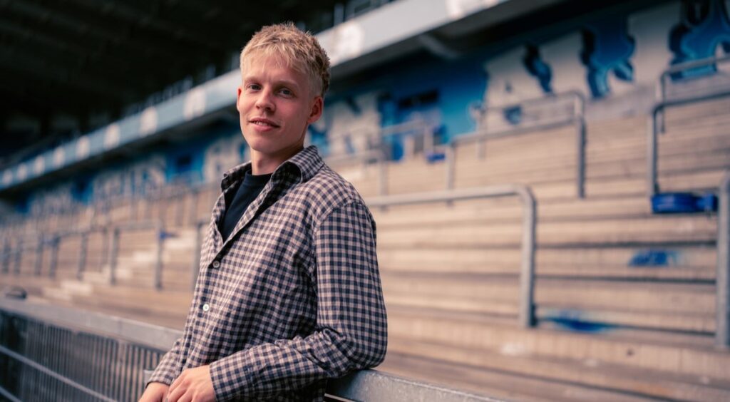 Jeppe Erenbjerg med tribunen i belgiske Genk i baggrunden.