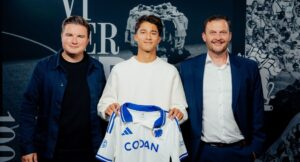 Sean Fetterlein holder en FCK-trøje frem.