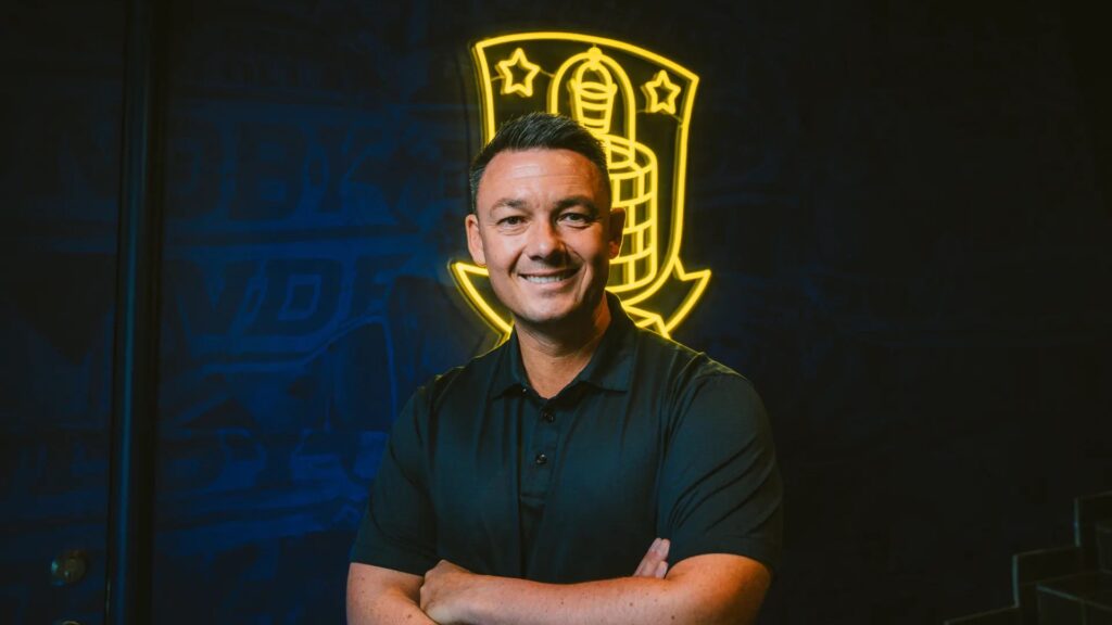Thomas Nørgaard med armene over kors og et Brøndby-logo i baggrunden.