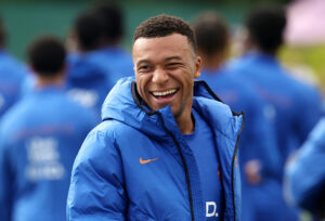 Kylian Mbappé griner.