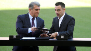 Joan Laporta og Xavi står med en kontrakt i hånden