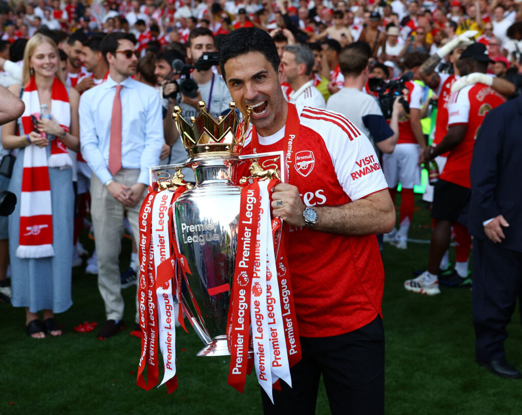 Mikel Arteta bider i Premier League-trofæet.