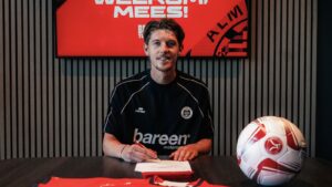 Mees Hoedemakers skriver under på en kontrakt i Almere City.