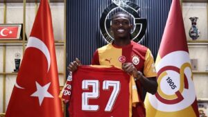 Rafael Leo med det et tyrkisk og galatasaray-flag i baggrunden.
