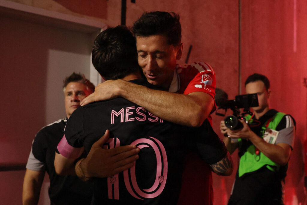 Lionel Messi og Robert Lewandowski krammer.