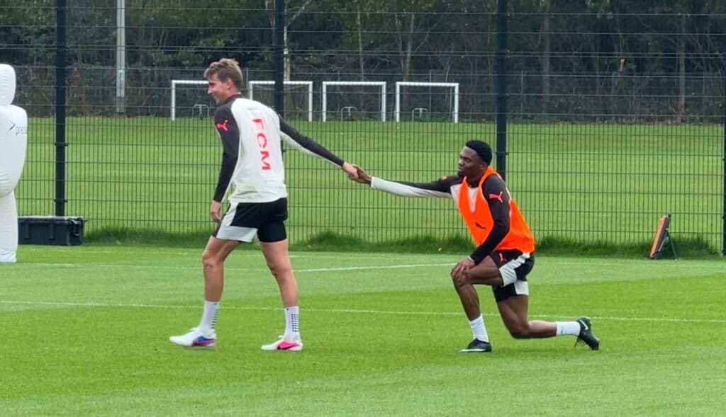 Andreas Maxsø hjælper Friday Etim op til træning i FC Midtjylland.